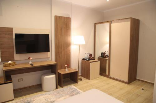 a hotel room with a television and a room at Jewel Assiut Hotel in Asyut