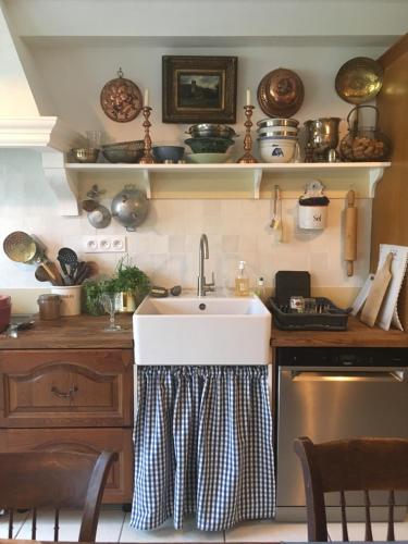 une cuisine avec un évier et de nombreux casseroles et poêles dans l'établissement les chambres de la tour, au Bec-Hellouin