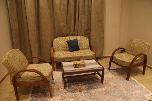 a living room with two chairs and a coffee table at Jewel Assiut Hotel in Asyut