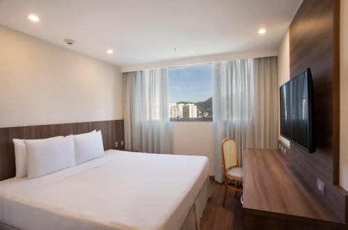 Un dormitorio con una cama grande y una ventana en Windsor Tower Hotel en Río de Janeiro
