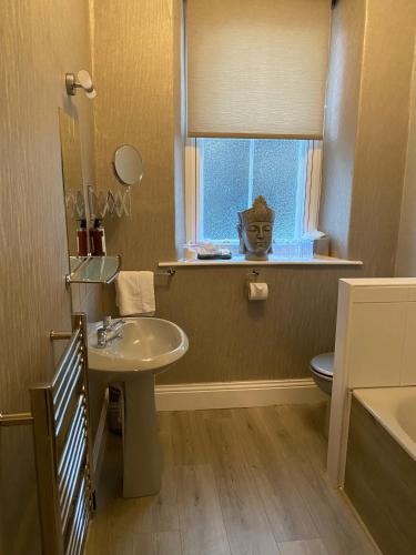 a bathroom with a sink and a toilet and a window at Merewyke Boutique Family Apartment Sleeps 4 , Only 5 Minutes Walk To Lake Windermere in Windermere