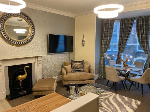 a living room with a fireplace and a dining room at Merewyke Boutique Luxury Family Apartment Sleeps 4 , Central Location in Windermere