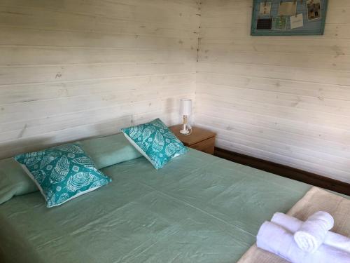a bedroom with a green bed with blue pillows at Posada Agua Marina in La Paloma
