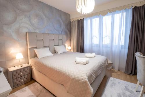 a bedroom with a large bed with two towels on it at Beograd na vodi - BW ViSTA LUXURY in Belgrade