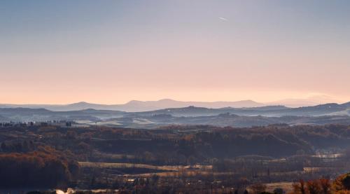 a view of a valley with trees and mountains at Borgo Argiano in Castelnuovo Berardenga