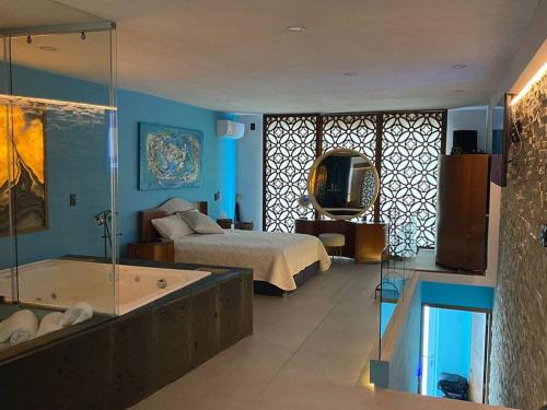 1 dormitorio con cama, bañera y TV en Luxury loft Mamitas Beach Jacuzzi&Sauna Barbacue, en Playa del Carmen