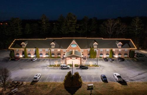 um grande edifício com carros estacionados num parque de estacionamento em Mountain Inn & Suites Flat Rock em Flat Rock