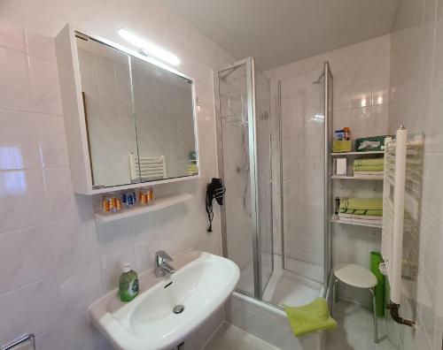 a white bathroom with a sink and a shower at Verwöhn-Pension Wiesengrund in Bischofsgrün