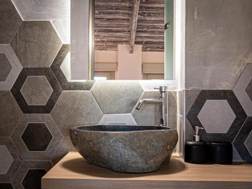 a bathroom with a large stone bowl sink at Perla Luxury Living in Parga