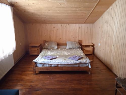 マイコリチンにあるУ Василяの木製の部屋にベッド1台が備わるベッドルーム1室があります。