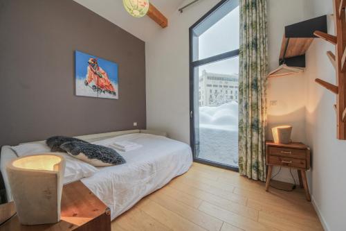 a bedroom with a bed and a large window at Maison Des Praz Chamonix in Chamonix-Mont-Blanc