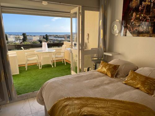 une chambre avec un lit et un balcon avec vue dans l'établissement SHOWTIME NATURISTE PORT NATURE 6 parking privé clim ascenseur vue mer, au Cap d'Agde