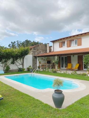 a swimming pool in front of a house at Casa de Alventela - Countryside House in Paredes de Viadores