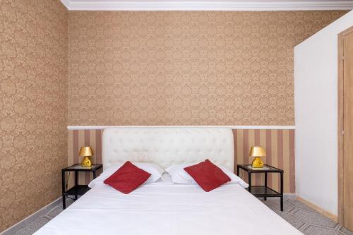 a bedroom with a white bed with two red pillows at [PIAZZA DI SPAGNA 5 STELLE] Parlamento Room in Rome