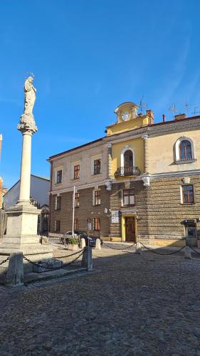a large building with a statue in front of it at APARTAMENT PLAC KATEDRALNY in Tarnów