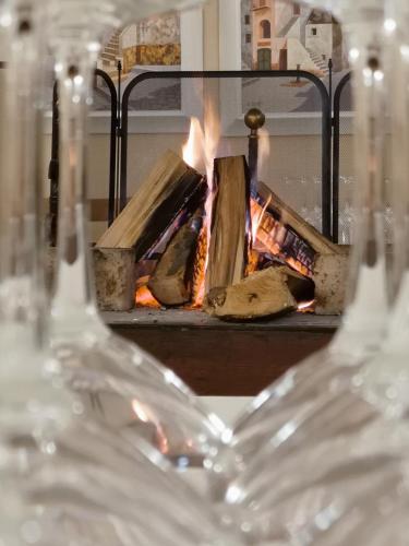 two wine glasses in front of a fire place at Hotel Roma in Palmanova