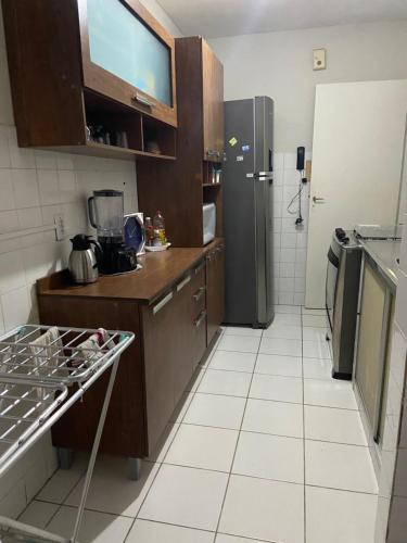 uma cozinha com um frigorífico e piso em azulejo branco em Jatiuca 2 em Maceió