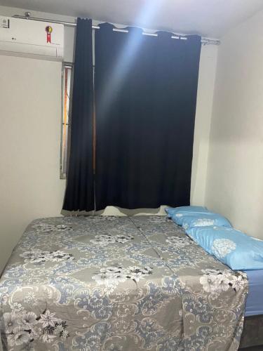 uma cama num quarto com uma cortina azul em Jatiuca 2 em Maceió