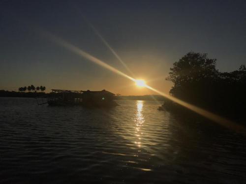 słońce zachodzące nad wodą w obiekcie Pousada Porto Marola w mieście Porto de Galinhas