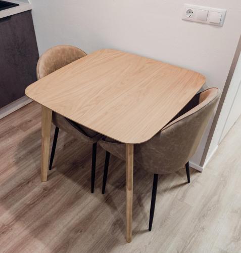 a wooden table with two chairs around it at MyApartments Kotka in Tallinn