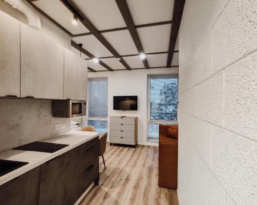 a kitchen with white cabinets and a large window at MyApartments Kotka in Tallinn