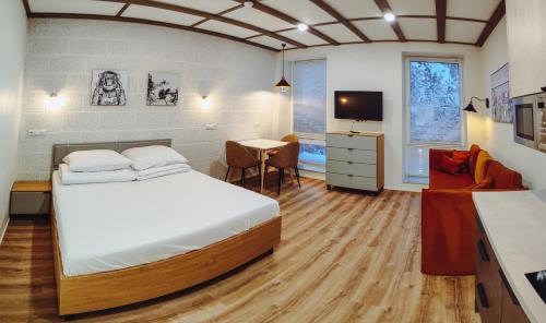 um quarto com uma cama, uma secretária e uma televisão em MyApartments Kotka em Talin