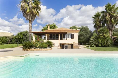 una casa con piscina di fronte a una casa di Alghero Villa Paradiso lusso per 12 ospiti ad Alghero