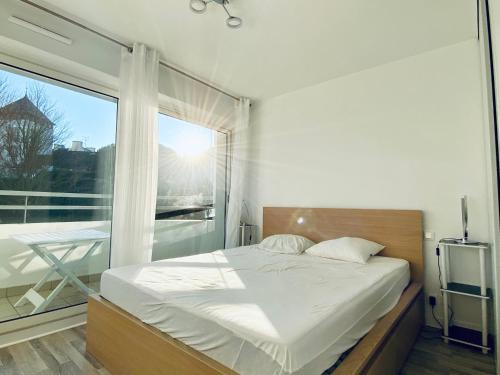 une chambre avec un lit et une grande fenêtre dans l'établissement REF 062 Appartement T3 pour quatre personnes proche port Crouesty à ARZON, à Arzon