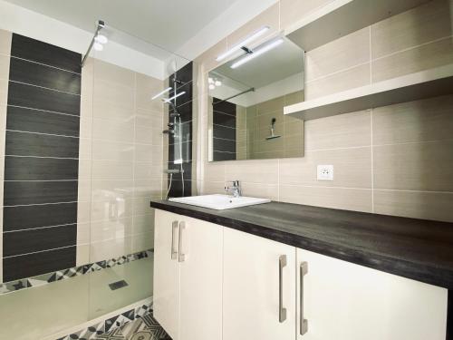 une salle de bain avec un lavabo et un miroir dans l'établissement REF 062 Appartement T3 pour quatre personnes proche port Crouesty à ARZON, à Arzon