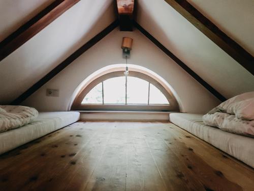 an attic room with two beds and a window at Villa Hubertus in Srebrna Góra