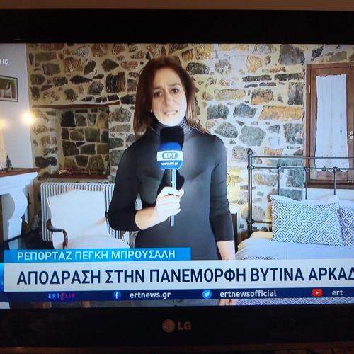 a woman is holding a microphone on a television screen at Archontiko Nikolopoulou in Vytina