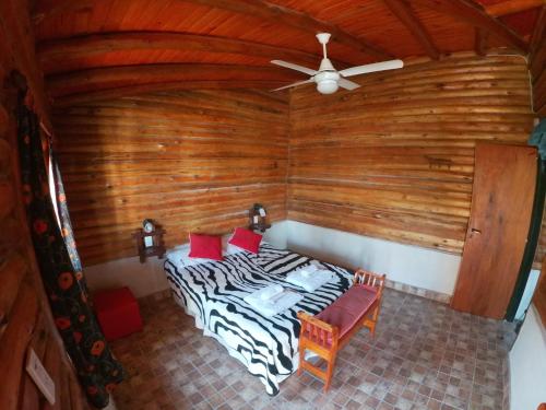 a bedroom with a bed and a ceiling fan at Aguila Blanca in Mina Clavero