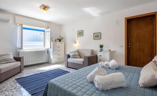 阿尔盖罗Attico Mir el Mar Alghero con spettacolare terrazza panoramica vista mare的卧室里有一张蓝色的床，床上放着毛巾