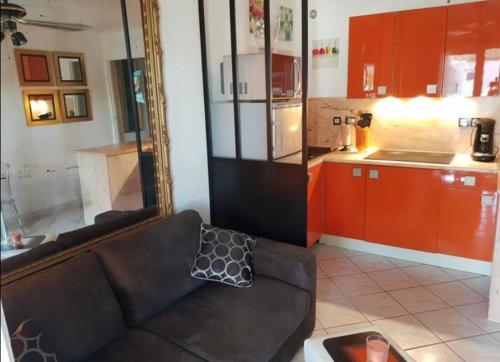 a living room with a couch and a mirror at Clair de plage in Frontignan