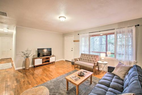 a living room with a couch and a tv at Centrally Located Hot Springs Home with Deck! in Hot Springs