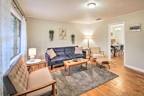 a living room with a blue couch and a table at Centrally Located Hot Springs Home with Deck! in Hot Springs