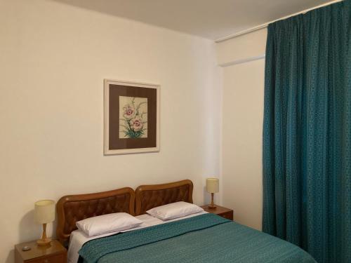 um quarto com uma cama com um cobertor azul e uma janela em Petrópolis Palácio Quitandinha em Petrópolis