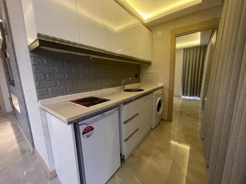 a small kitchen with a sink and a dishwasher at Le Luxe Suites Hotel & Spa in Bursa