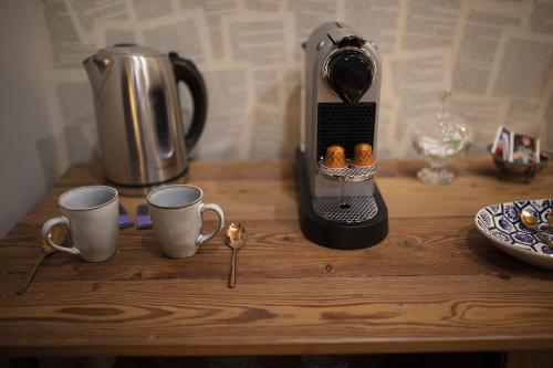 a coffee maker sitting on a table with two cups at The Lake House in Viverone