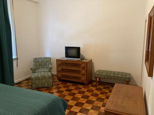 - une chambre avec un lit, une télévision et une chaise dans l'établissement Petrópolis Palácio Quitandinha, à Petrópolis