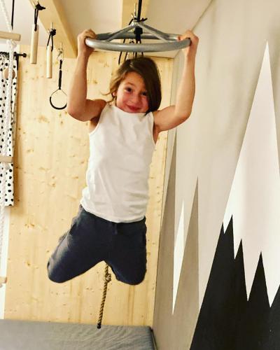 a girl is hanging on a rail in a room at Oskar Apartments in Neustift im Stubaital