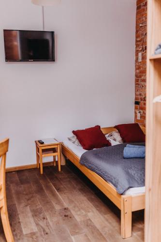 a bedroom with a bed and a tv on the wall at Villa Hubertus in Srebrna Góra