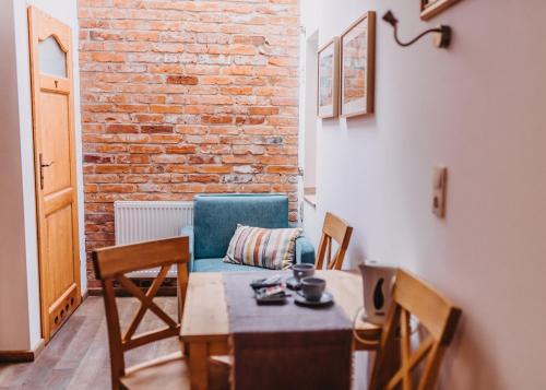 a dining room with a table and chairs and a brick wall at Villa Hubertus in Srebrna Góra