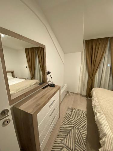 a bedroom with a mirror on a dresser and a bed at Milmari Apartman N92 Kopaonik in Kopaonik
