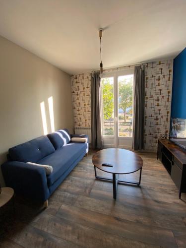 a living room with a blue couch and a coffee table at L’havrais détente in Le Havre