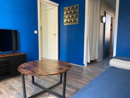 une chambre avec une table et un mur bleu dans l'établissement L’havrais détente, au Havre