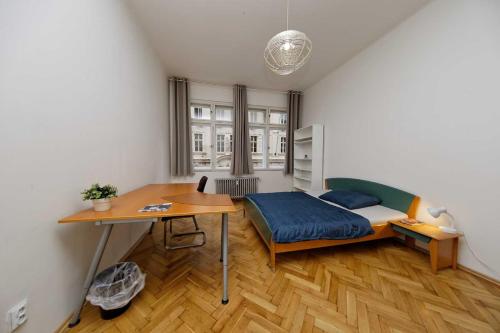 a bedroom with a bed and a desk and a table at Apartments Vorsilska in Prague