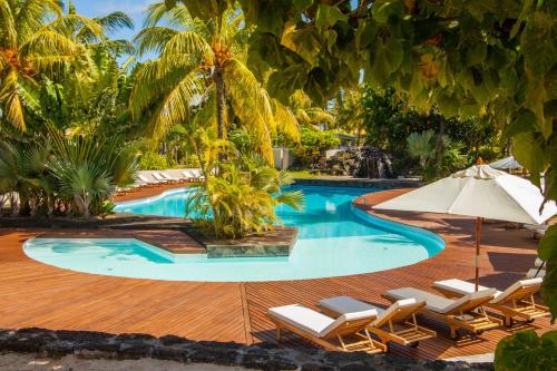 a swimming pool with lounge chairs and an umbrella at Solana Beach Mauritius - Adults Only in Belle Mare