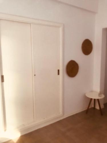 a room with white walls and a door and a stool at Monoambiente in Buenos Aires