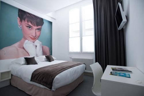 une chambre avec un lit et une peinture d'un homme dans l'établissement Hôtel François 1er, à La Rochelle